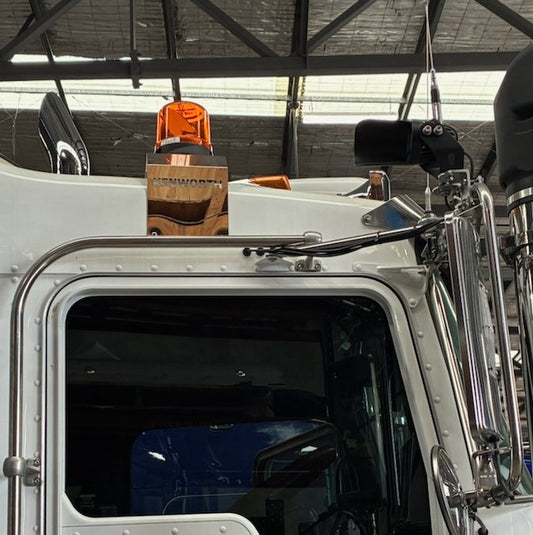 Stainless beacon brackets T909, T659, and C509 by RTE Custom Trucks displayed on a wooden surface.